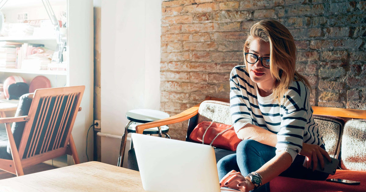 Young white woman uses laptop on the coffee table